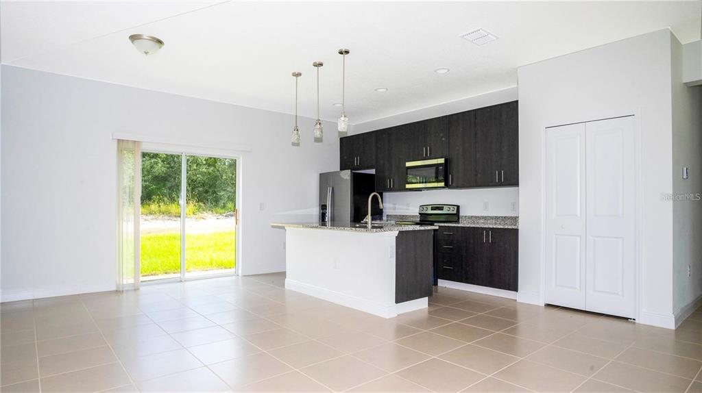 4147 Southwest 167th Street Ocala, FL 34473 - Photo 7 of 45 a kitchen with kitchen island a counter top space appliances a sink and a window