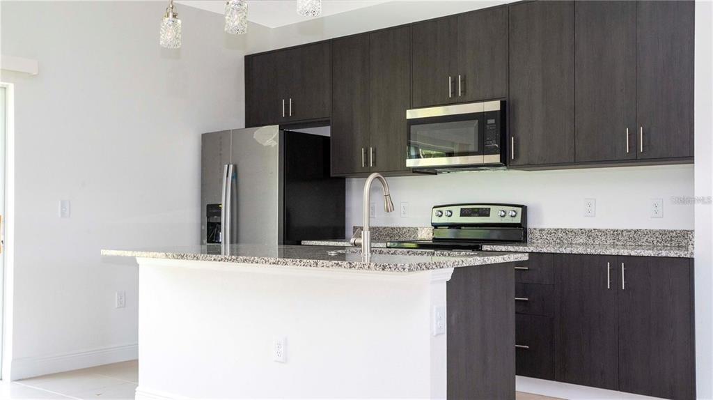 4147 Southwest 167th Street Ocala, FL 34473 - Photo 8 of 45 a kitchen with stainless steel appliances granite countertop a refrigerator stove and microwave
