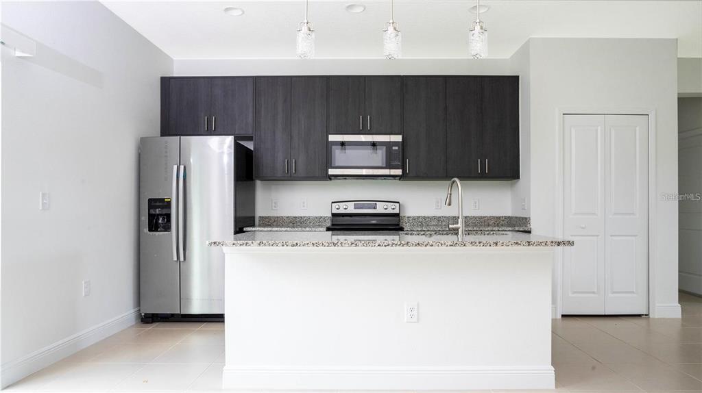 4147 Southwest 167th Street Ocala, FL 34473 - Photo 10 of 45 a kitchen with stainless steel appliances granite countertop a refrigerator a stove a sink and a microwave