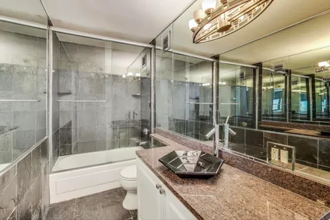 a bathroom with a tub shower sink and toilet
