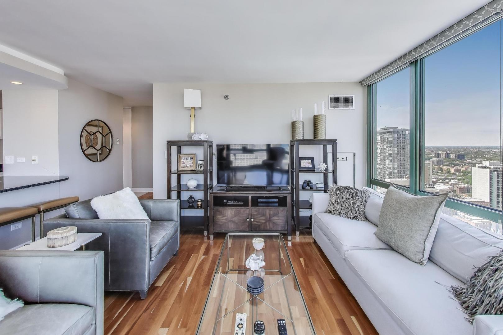111 West Maple Street, Unit 2601 Chicago, IL 60610 - Photo 5 of 23 a living room with furniture and a large window