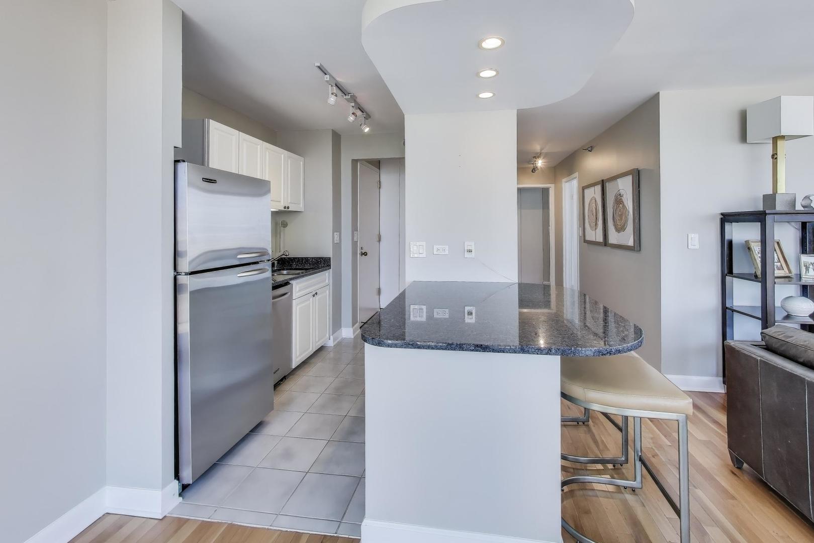 111 West Maple Street, Unit 2601 Chicago, IL 60610 - Photo 9 of 23 a kitchen with stainless steel appliances granite countertop a refrigerator and a stove top oven