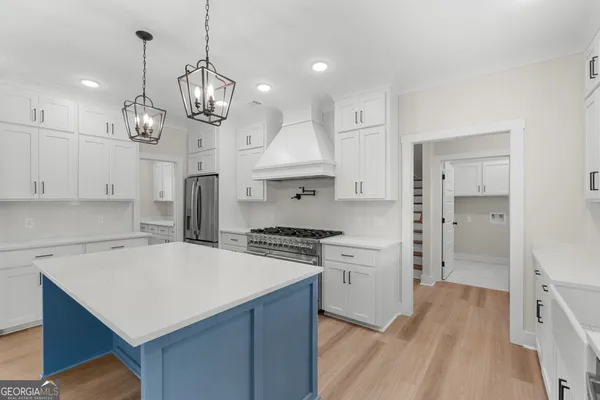 a kitchen with a stove a refrigerator a sink and chairs