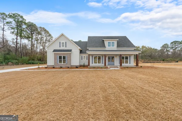 a front view of house with yard and trees around