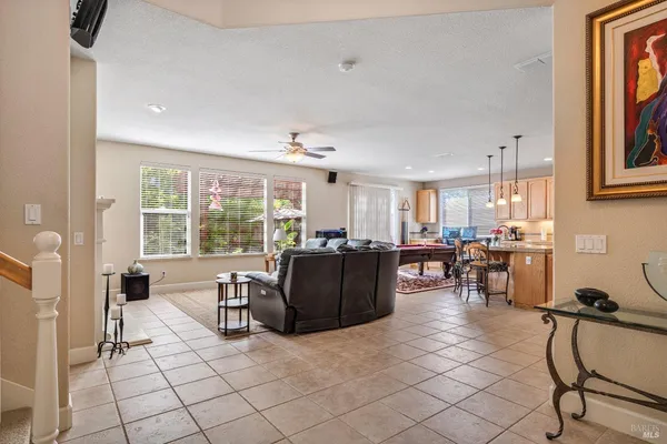 a living room with couches and kitchen view with wooden floor