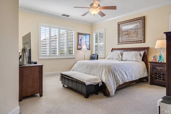 a spacious bedroom with a bed and a chandelier
