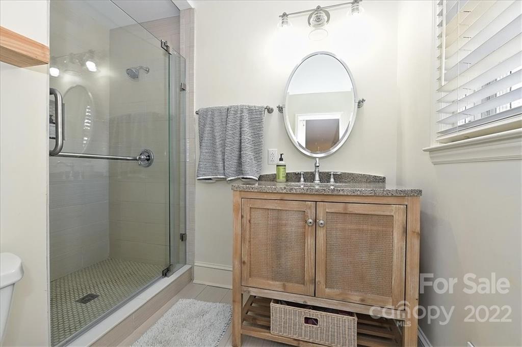 5638 Londonderry Road Charlotte, NC 28210 - Photo 25 of 44 a bathroom with a granite countertop sink a mirror and a shower