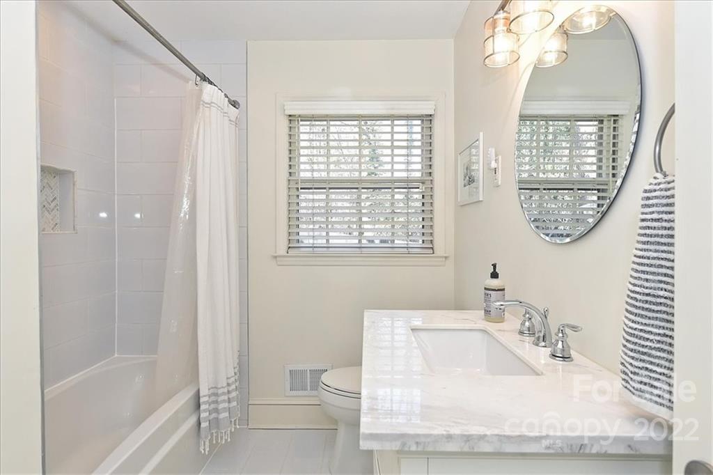 5638 Londonderry Road Charlotte, NC 28210 - Photo 29 of 44 a bathroom with a granite countertop sink a mirror and a shower