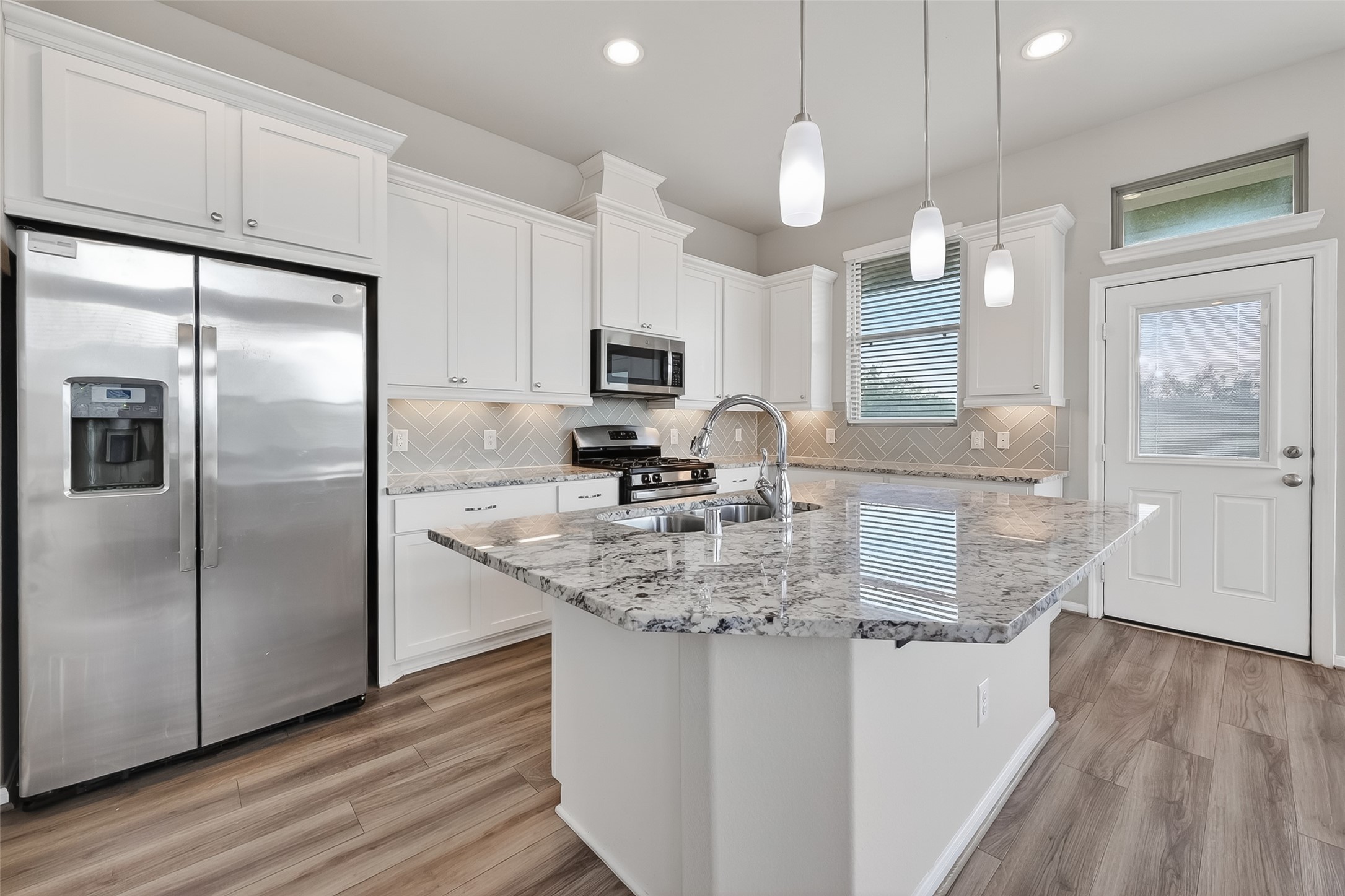 16226 Rattlesnake Run Trail Cypress, TX 77433 - Photo 10 of 29 a kitchen with stainless steel appliances granite countertop a refrigerator a sink a stove and a wooden floors