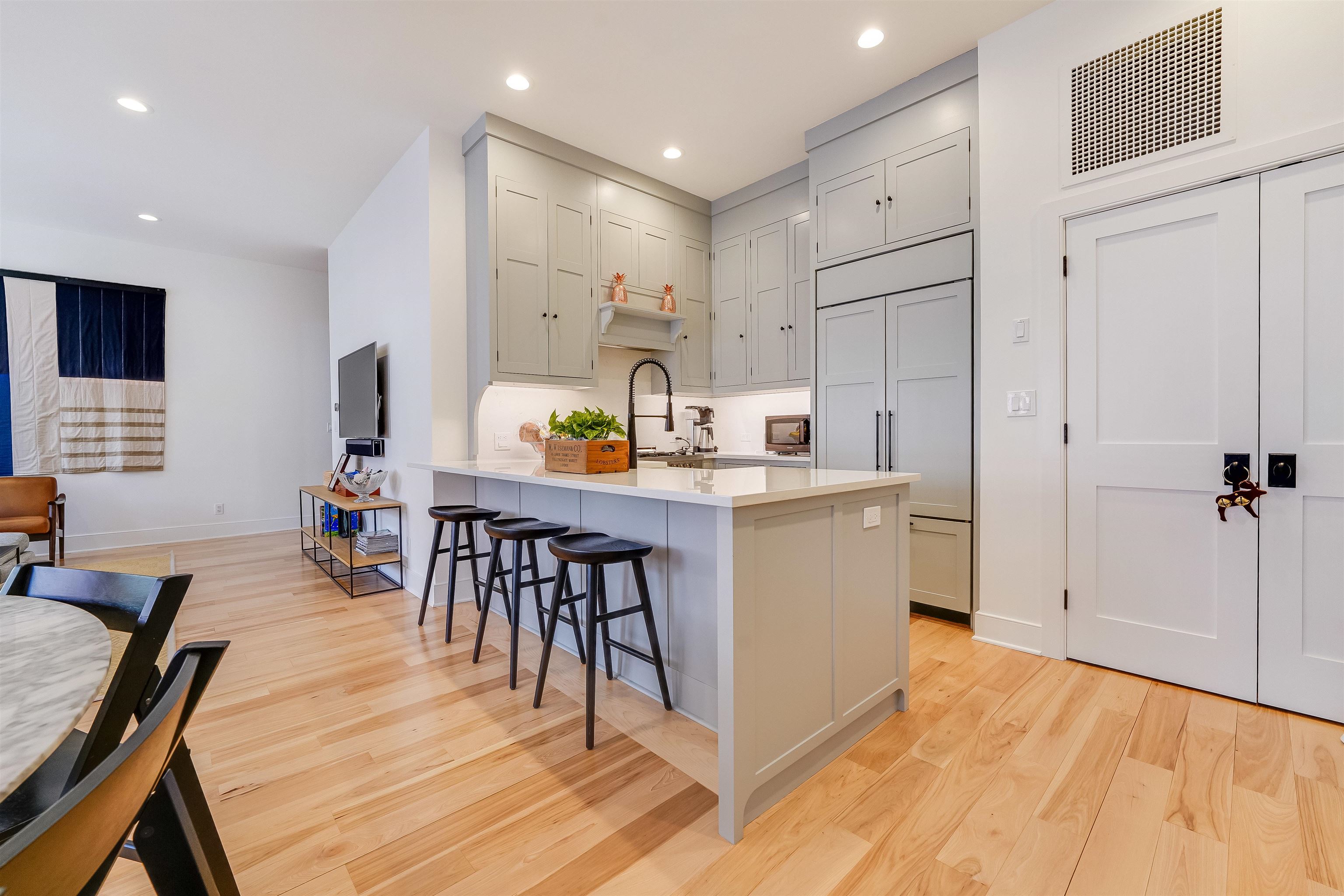 222 Clinton Street, Unit 19 Hoboken, NJ 07030 - Photo 11 of 31 a open kitchen with stainless steel appliances granite countertop a stove top oven a sink a dining table and chairs with wooden floor