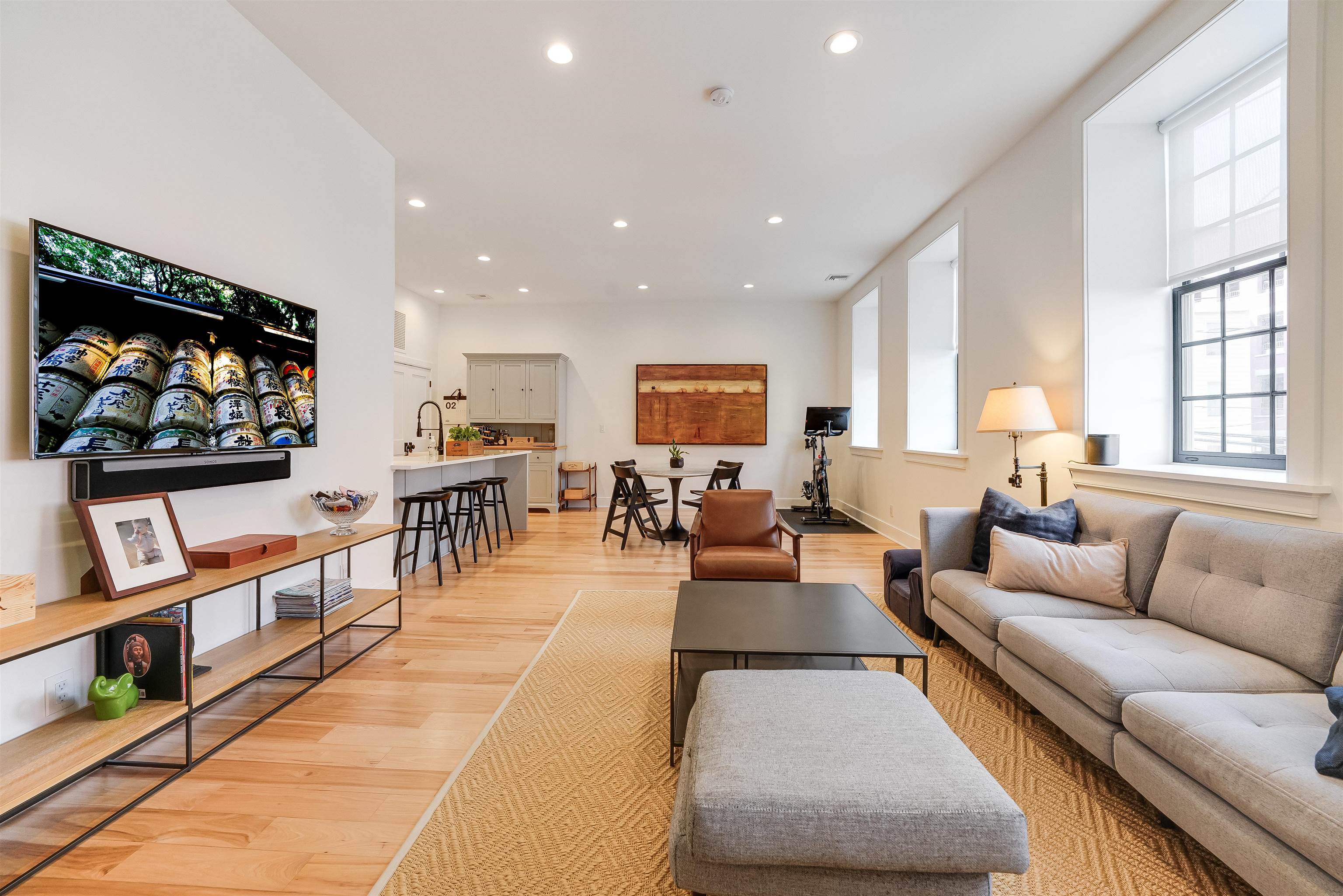222 Clinton Street, Unit 19 Hoboken, NJ 07030 - Photo 2 of 31 a living room with furniture a flat screen tv and a floor to ceiling window