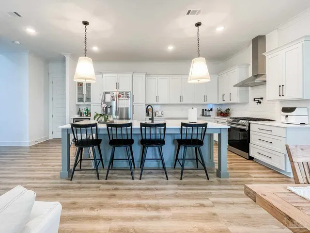 a dining room filled chandelier and kitchen view