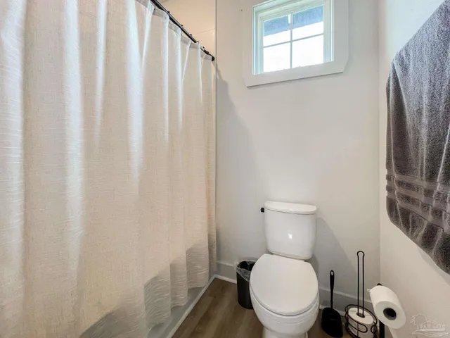 a white toilet sitting next to a small window