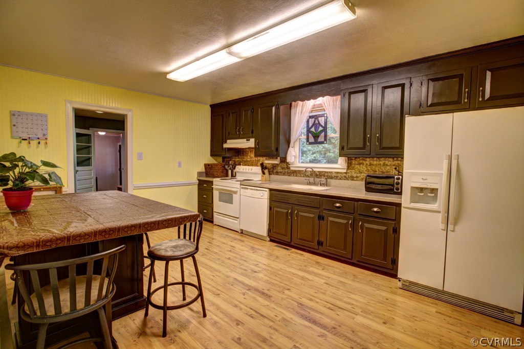 18411 Beaver Dam Road Beaverdam, VA 23015 - Photo 4 of 24 a kitchen with stainless steel appliances granite countertop a stove a refrigerator a sink a dining table and chairs with wooden floor