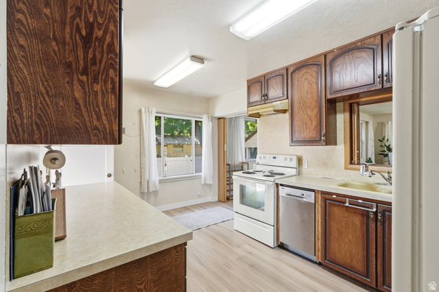 270 East 700 North Logan, UT 84321 - Photo 6 of 42 Kitchen featuring wood-finish cabinetry, light-toned countertops, and wood-finish flooring