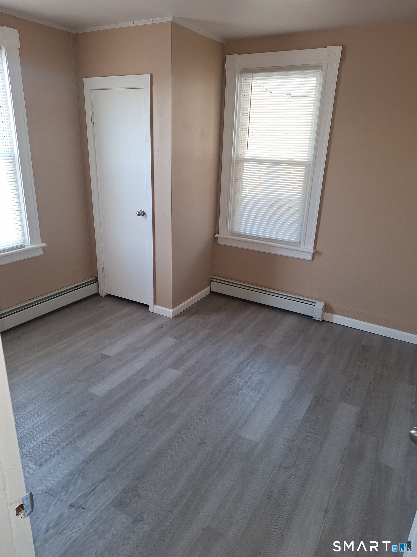 23 1/2 North Spring Street, Unit 3 Ansonia, CT 06401 - Photo 11 of 12 an empty room with wooden floor and windows