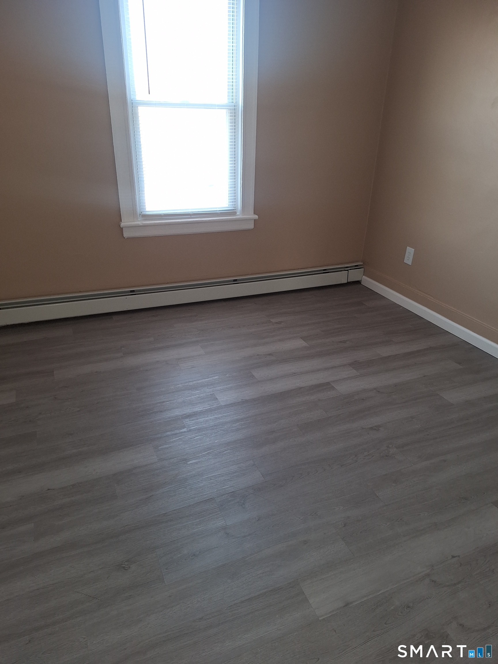 23 1/2 North Spring Street, Unit 3 Ansonia, CT 06401 - Photo 10 of 12 an empty room with wooden floor and windows