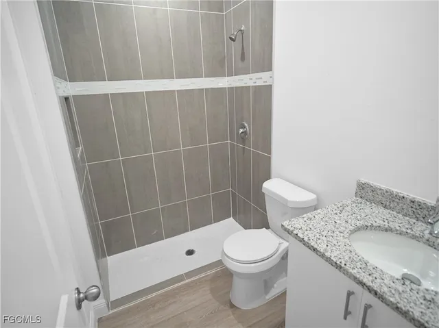 a view of a kitchen with white cabinets and wooden floor