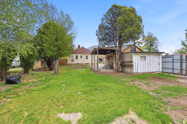 676 South 500 West Provo, UT 84601 - Photo 28 of 29 Back of house featuring a patio, a fenced backyard, and a storage shed