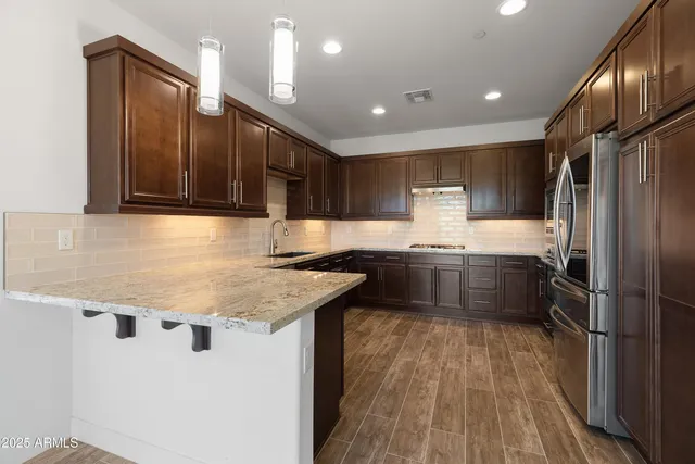 a kitchen with stainless steel appliances granite countertop a sink refrigerator and cabinets
