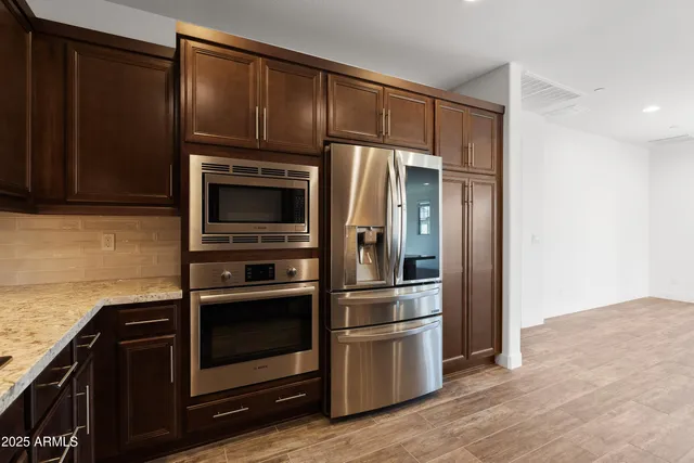 a kitchen with granite countertop stainless steel appliances and wooden cabinets