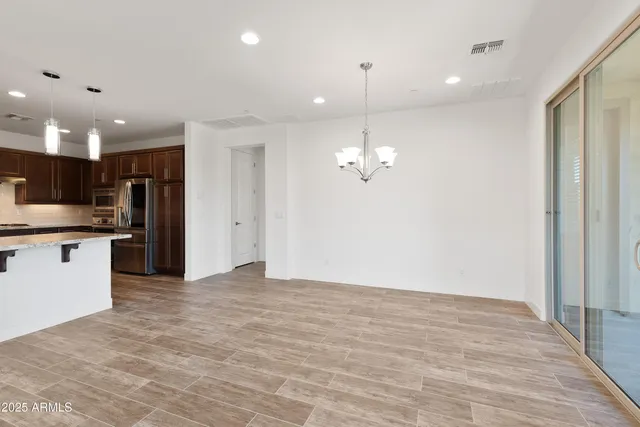 a view of a kitchen with an empty space and wooden floor