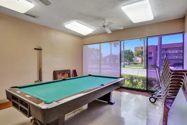 a room with pool table and windows