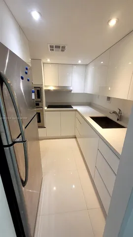 a kitchen with a sink a refrigerator and cabinets