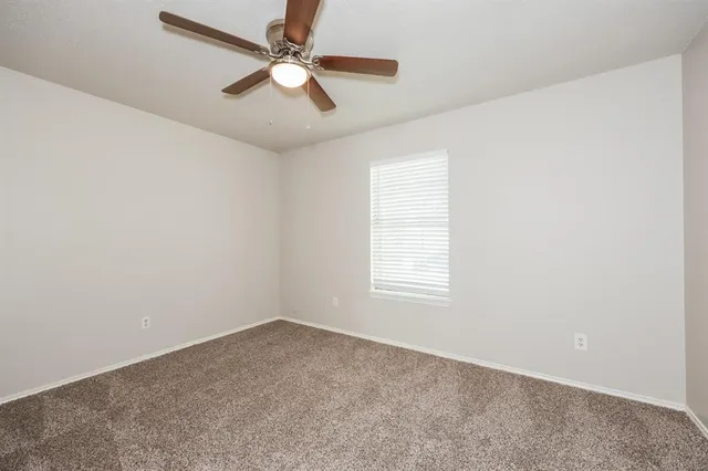 an empty room with a window and a fan