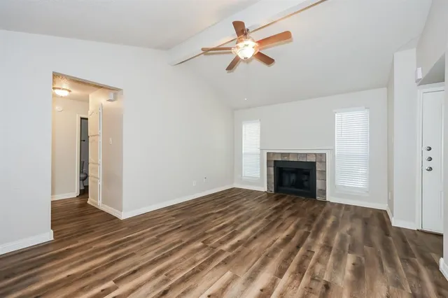 a view of empty room with wooden floor and fireplace