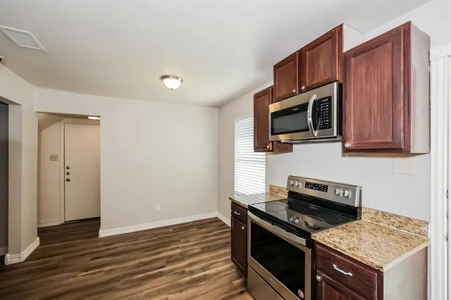 a kitchen with stainless steel appliances granite countertop a stove microwave and refrigerator
