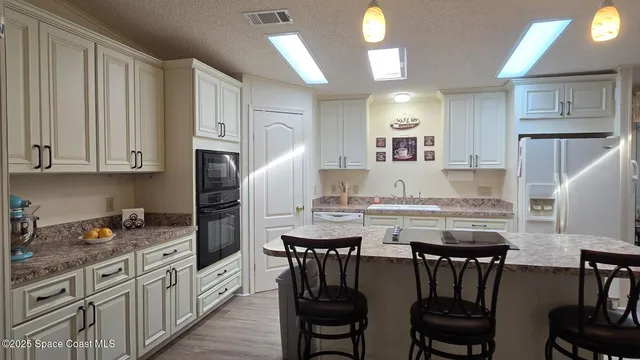 a kitchen with granite countertop a table chairs stove and cabinets