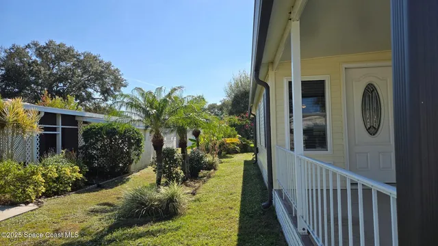 a view of a porch with plants and wooden fence