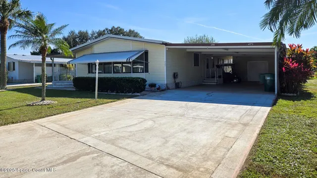 a view of a house with backyard and sitting area