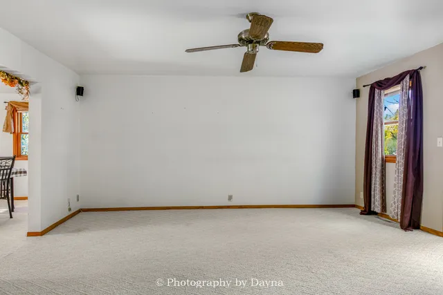 an empty room with a ceiling fan and a window