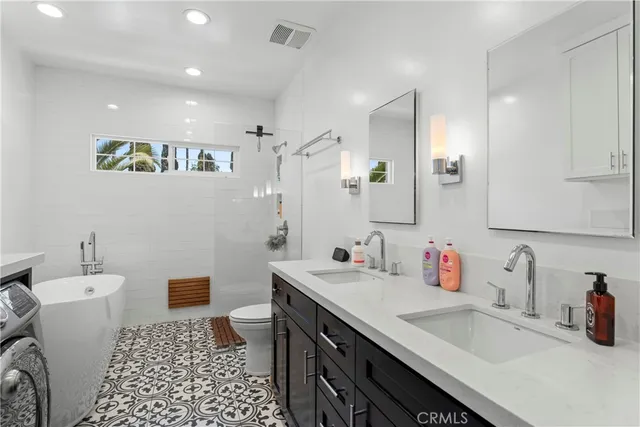 a bathroom with a sink a toilet a shower and a mirror