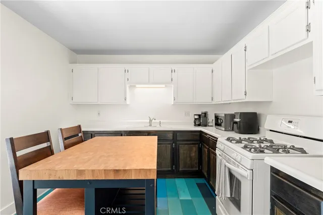 a kitchen with a sink a stove and cabinets