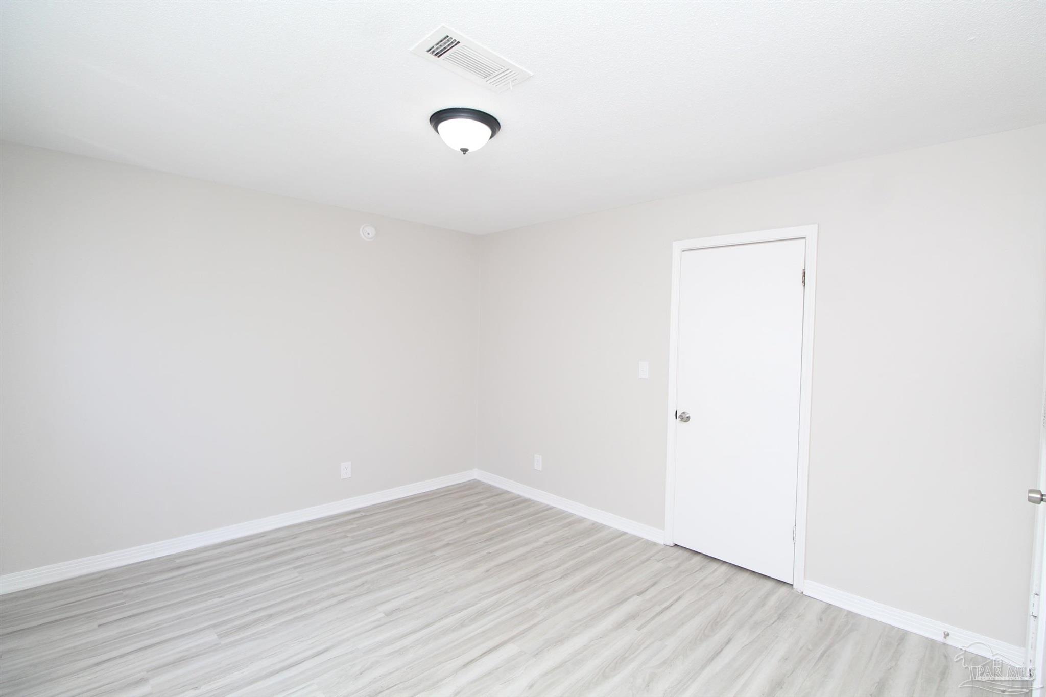 10151 Guidy Lane, Unit B2 Pensacola, FL 32514 - Photo 9 of 11 a view of a room with wooden floor