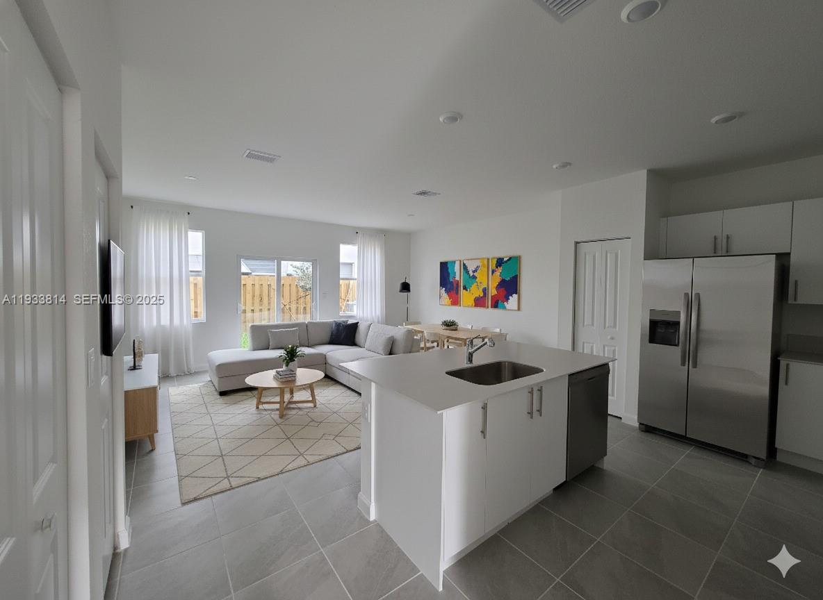 1082 Southeast 2nd Terrace, Unit 57 Homestead, FL 33034 - Photo 5 of 12 a kitchen with stainless steel appliances granite countertop a sink and a refrigerator