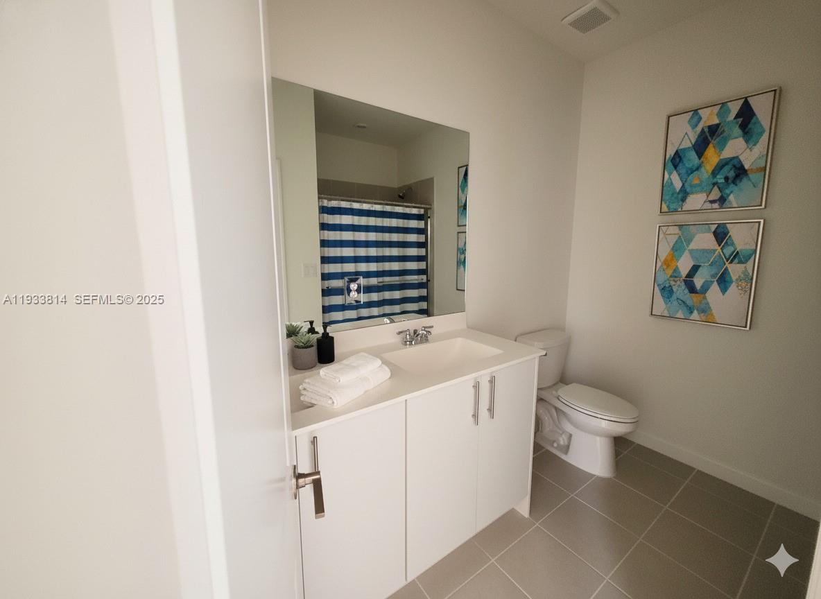 1082 Southeast 2nd Terrace, Unit 57 Homestead, FL 33034 - Photo 10 of 12 a bathroom with a sink a toilet and a mirror