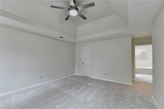 an empty room with a ceiling fan and a window