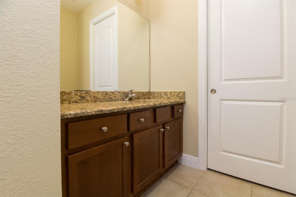 230 Southwest 2nd Avenue, Unit 207 Gainesville, FL 32601 - Photo 17 of 25 a bathroom with a granite countertop sink and a mirror