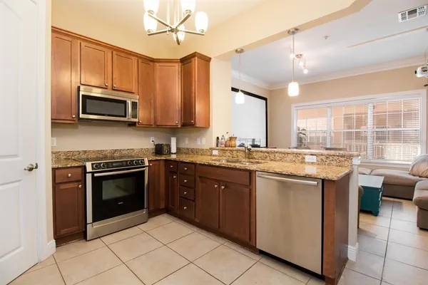 a kitchen with stainless steel appliances granite countertop a stove a sink and a microwave