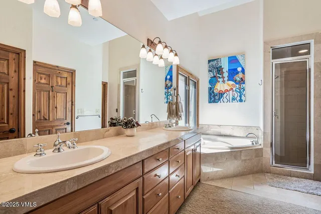 a bathroom with a double vanity sink mirror and bathtub