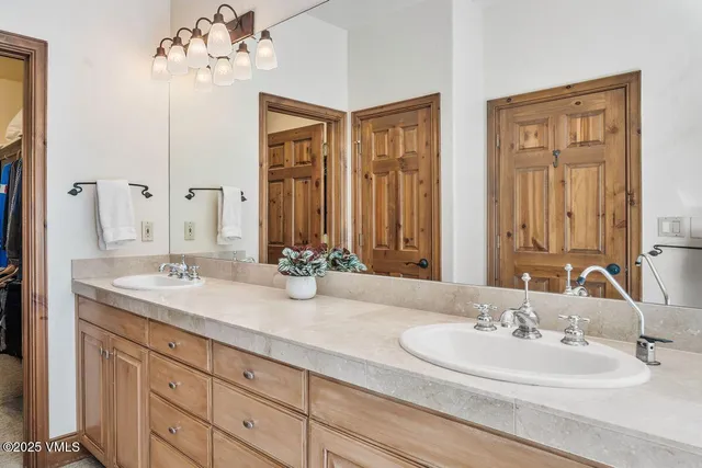 a bathroom with double vanity sinks a vanity and a mirror