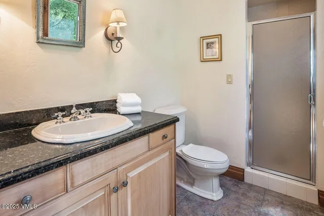 a bathroom with a granite countertop sink a toilet and a mirror