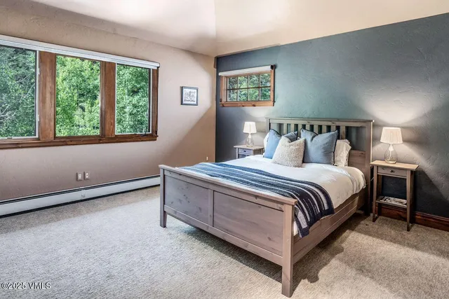 a bed sitting in a bedroom next to a window