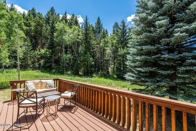 a view of a chairs and table on wooden deck with plants