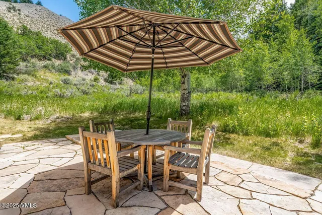 a patio with water view fountain with large trees