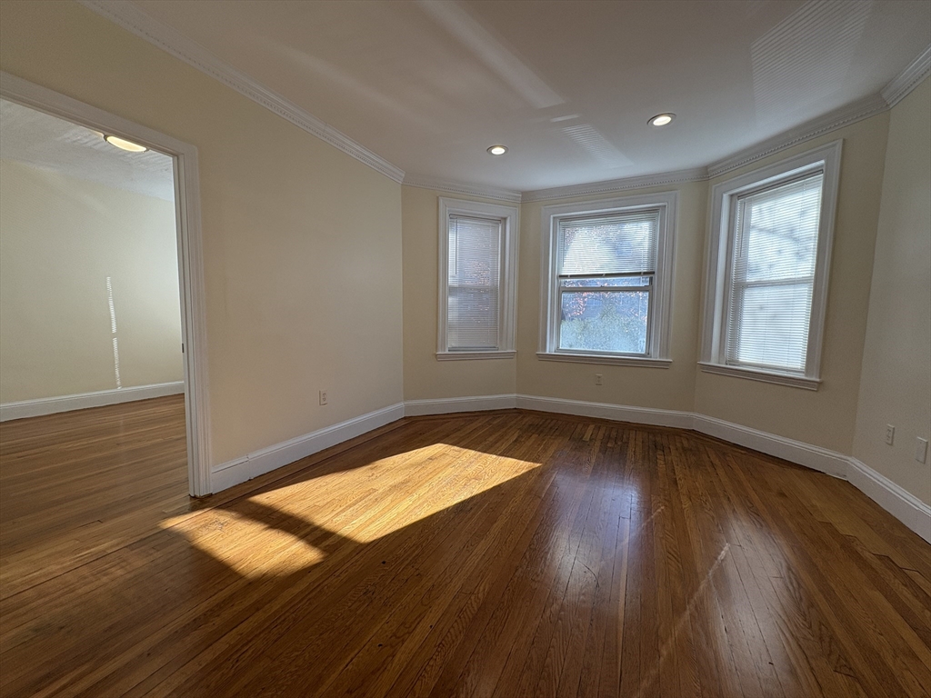 73 Thatcher Street, Unit 202 Brookline, MA 02446 - Photo 1 of 15 an empty room with wooden floor and windows